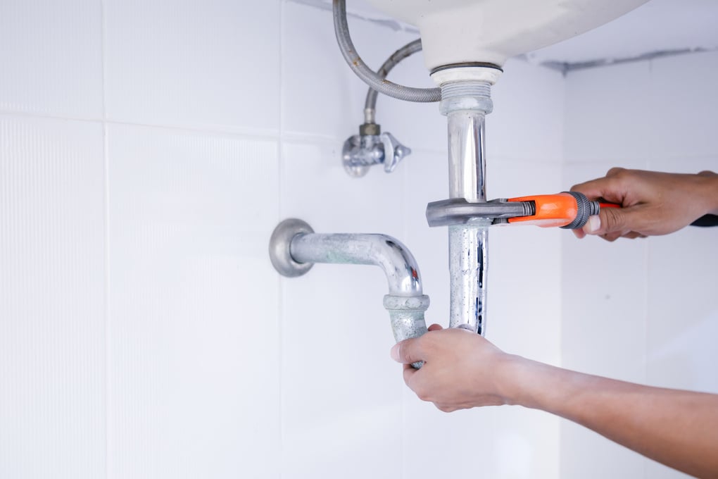 Plumber working in the bathroom, plumbing repair service.